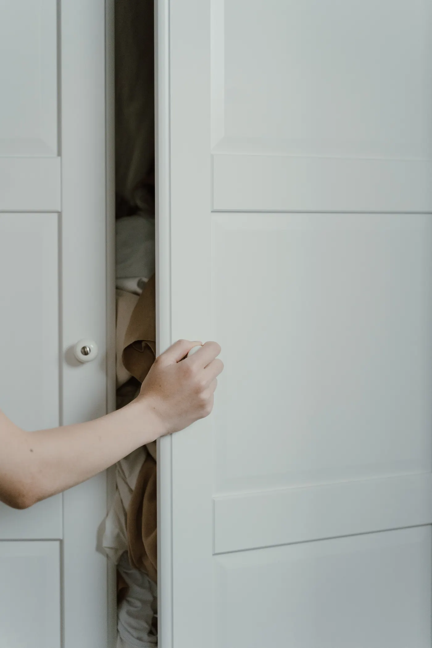White paneled closet door being opened